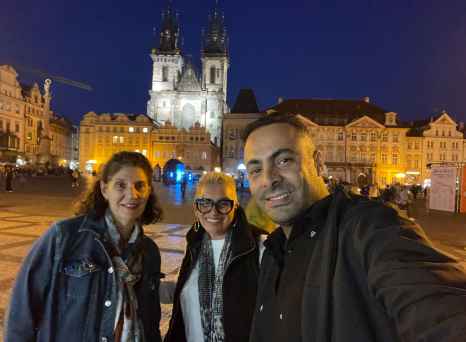 Three people in front of the Church of Our Lady before Týn in Prague.