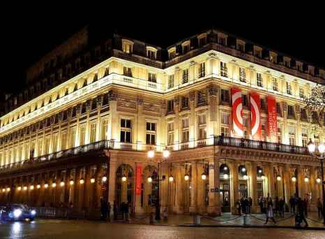 Théâtre du Palais-Royal in Paris prominently displaying red banners.