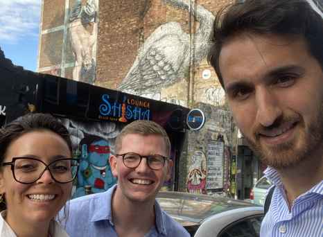 Street art featuring a large bird visible behind people on Brick Lane, London.