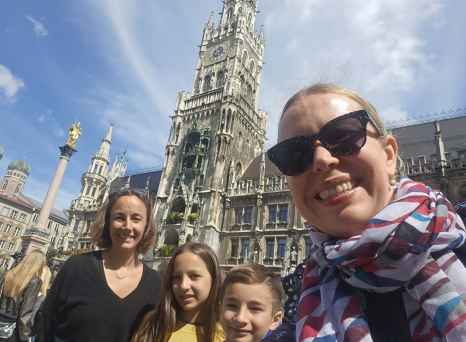 Tourists posing with the clock tower of New Town Hall behind them.
