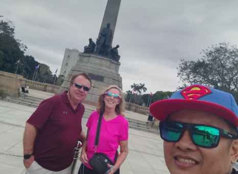 Strangers share a smile near Manila's historic Rizal Monument.