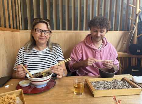 Two people dining at a Japanese restaurant table with soba noodles.