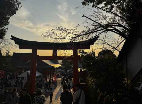 People walking through a torii gate at Fushimi Inari Shrine, Kyoto, Japan.