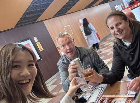 Group sitting at a table with Japanese menus and drinks.