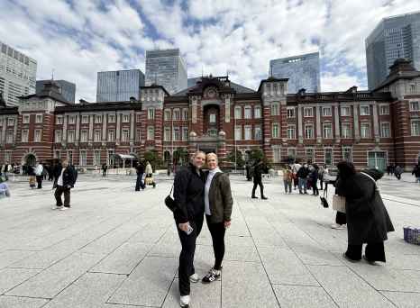 People standing in front of Tokyo Station with skyscrapers in the background.
