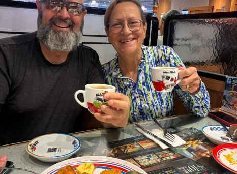 Tourists enjoying a warm cup of tea in a lively Hong Kong diner.
