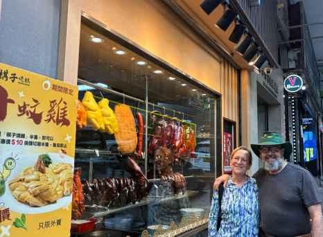 Visitors enjoying a moment outside a vibrant Hong Kong eatery display.