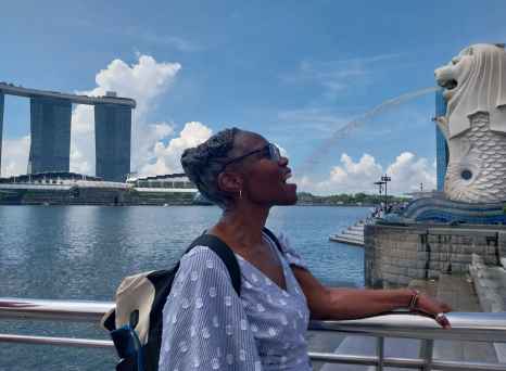 A playful moment with the Merlion's spray in Singapore.