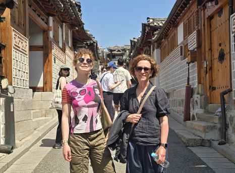 Strolling through Seoul's historic hanok village under a bright blue sky.