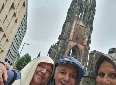 Enjoying a rainy day exploration by a towering church spire.