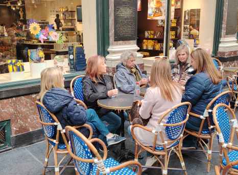 Friends share stories over coffee at a Brussels café.
