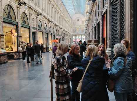 A group gathers around a shop window in Brussels' arcade.