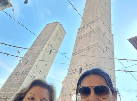 Towering Giants: A Smiling Moment Beneath Bologna's Skies