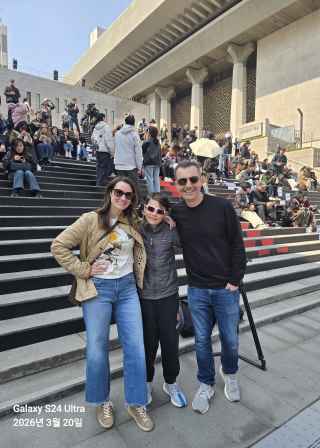 Three people posing on the steps at Sejong Center for the Performing Arts in Seoul.
