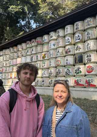 Visitors at Meiji Shrine with traditional sake barrels visible.
