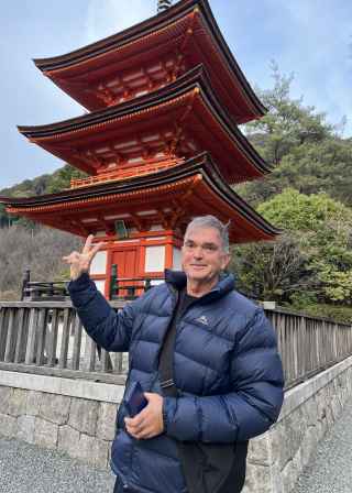 Man standing in front of the three-story pagoda at Kiyomizu-dera, Kyoto.