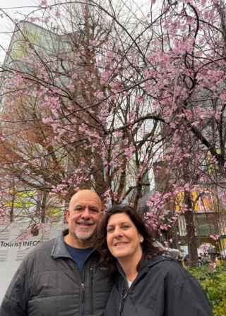 A couple enjoys the cherry blossoms on a cloudy Tokyo day.