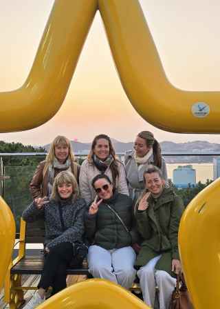 Laughter and peace signs under Busan's golden glow.