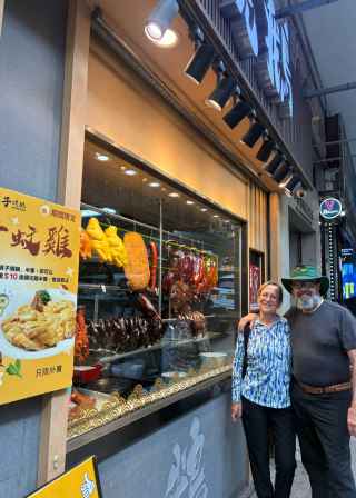 Visitors enjoying a moment outside a vibrant Hong Kong eatery display.