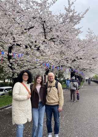 Travellers enjoying a walk under Tokyo's cherry blossoms.