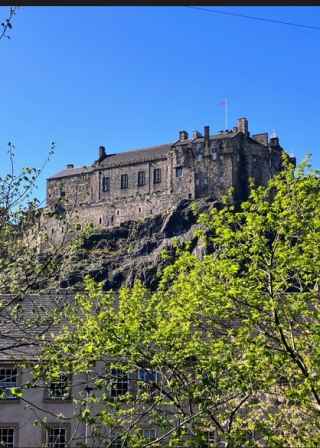 Edinburgh Castle stands majestically against a clear blue sky.