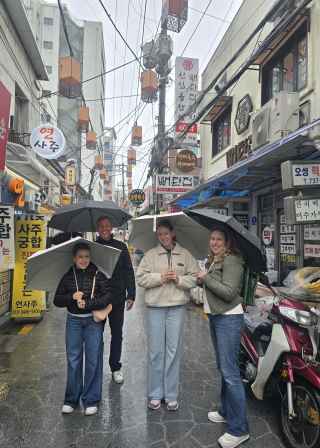 Enjoying a rainy day adventure in a vibrant Seoul neighborhood.