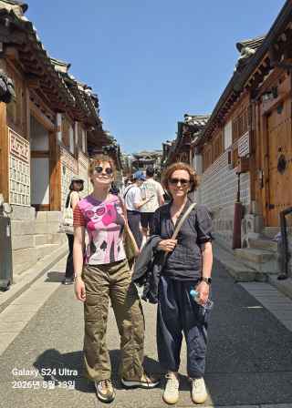 Strolling through Seoul's historic hanok village under a bright blue sky.