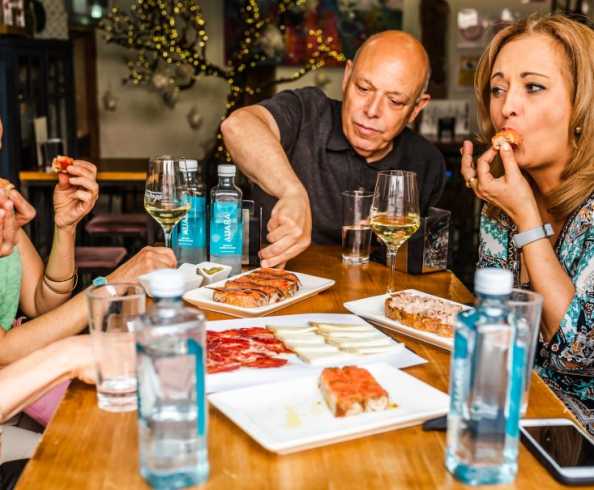 tableware,food,drinkware,table,furniture,alcoholic drink,customer,restaurant,smile,barware,alcohol,party,plate,sharing,liquor,fun,dishware,eating,beer,brunch,lunch,chair,conversation,supper,dinner,breakfast,wine,wine glass