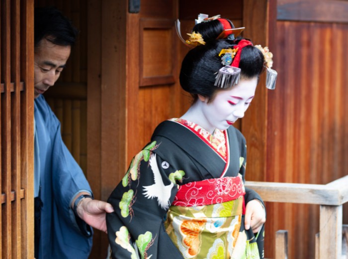 Geisha walking out of a traditional wooden structure