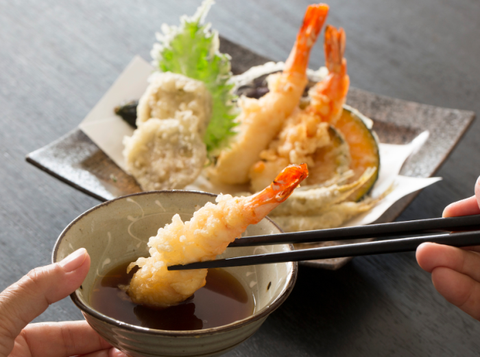 Tempura prawns been eaten with chopsticks