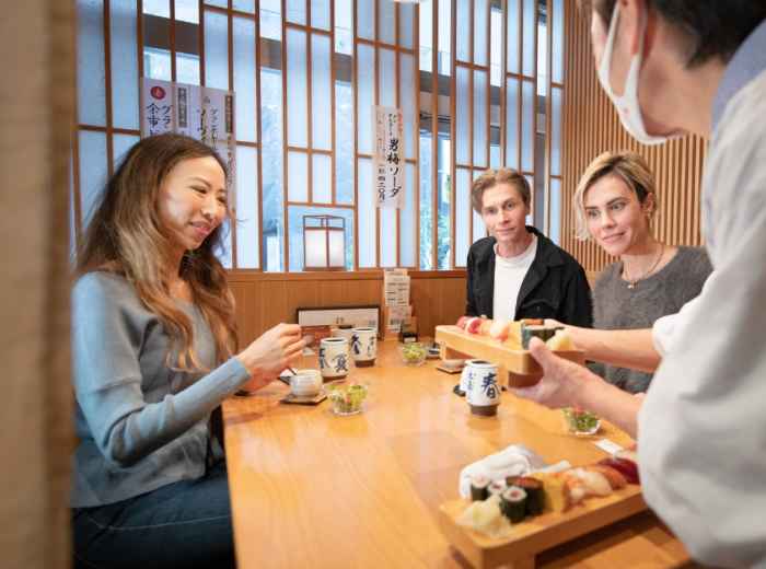 Travelers about to enjoy sushi with a local host in Tok