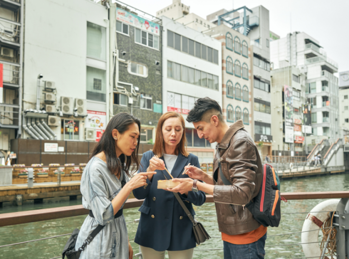 People eating street food in Osaka, Japan