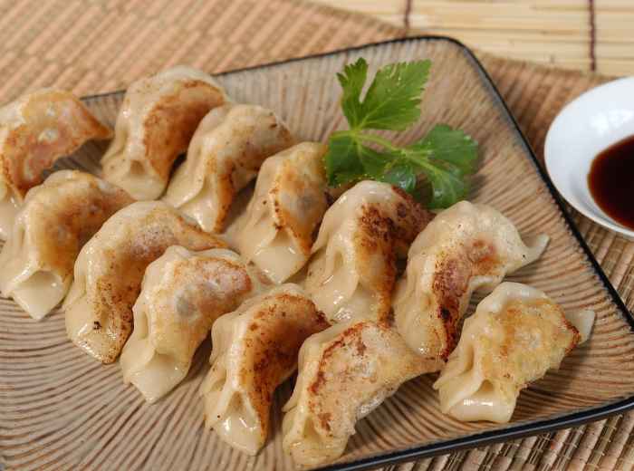Plate of grilled gyoza with dipping sauce on wooden counter photo by PerfectLinks Pixabay