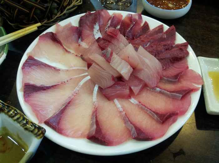 Seafood vendor arranging sashimi inside Kuromon. photo by truelife365 Pixabay