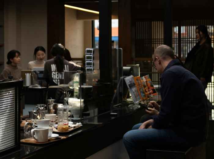 Local businessman reading newspaper at small café in Osaka city center. Image by inyoung jung from Unsplash