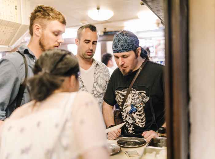 Host explaining dishes  to attentive guests.