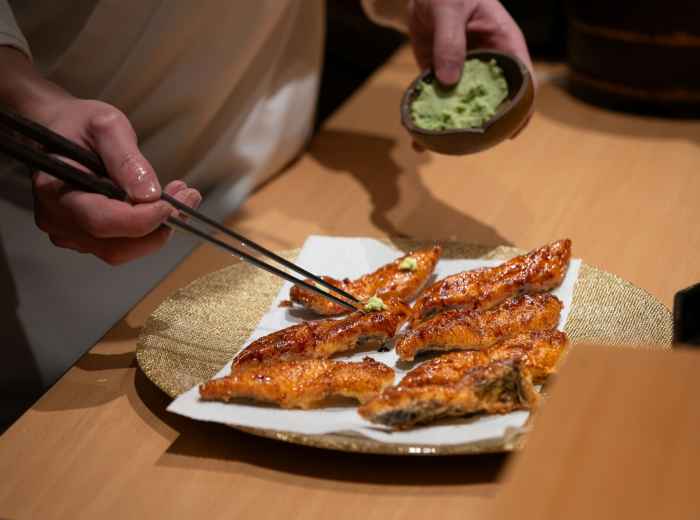 Dish being prepared to dietary preference with chef making adjustment. Image by Harrison Chang