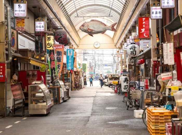 Covered market entrance mid-morning with vendors setting up.