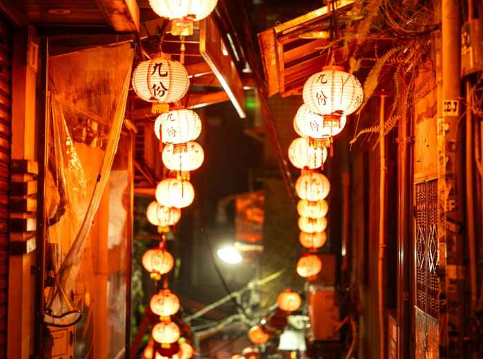 Narrow backstreet food alley with traditional lanterns. Image by  Marek Piwnicki from Unsplash