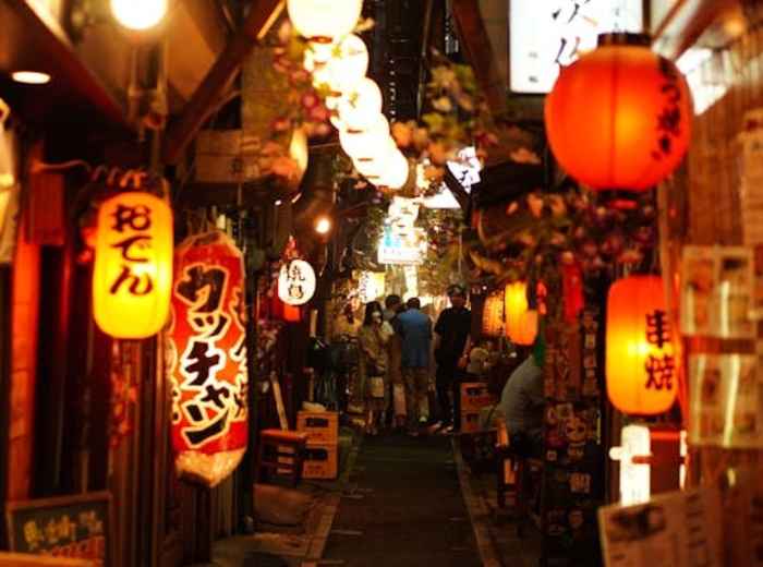Guests navigating a small passageway between street food stalls.