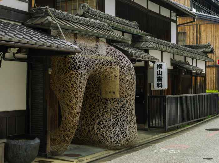 A tucked-away shrine between modern buildings. Image by Charlie Charoenwattana from Unsplash