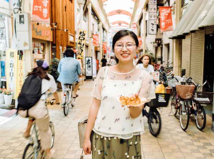 A takoyaki stand with a smiling host.