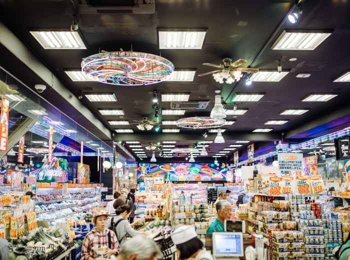 A host guiding travelers through a local shopping district.