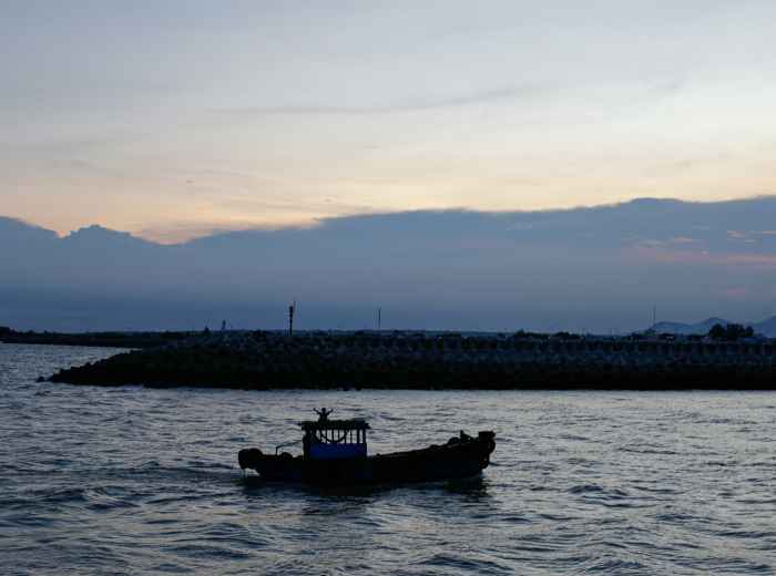 Osaka Bay at sunrise with fishing boats returning to harbor Photo by DIEU on Unsplash