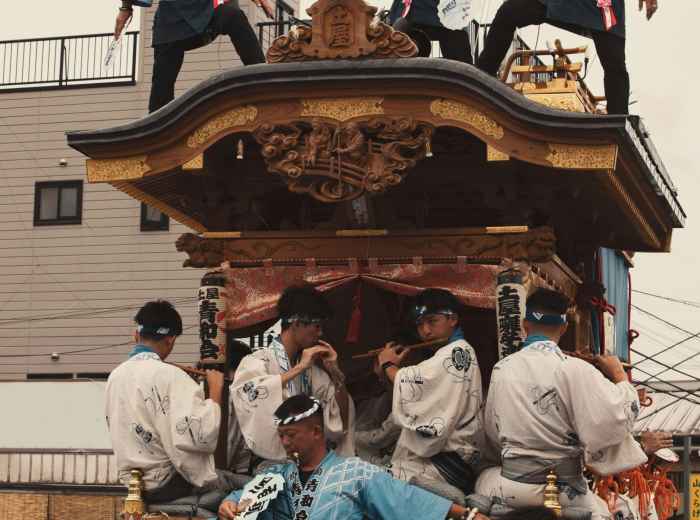 Traditional festival procession during Tenjin Matsuri with participants in historical costumes.  Photo by Nguyen TP Hai on Unsplash