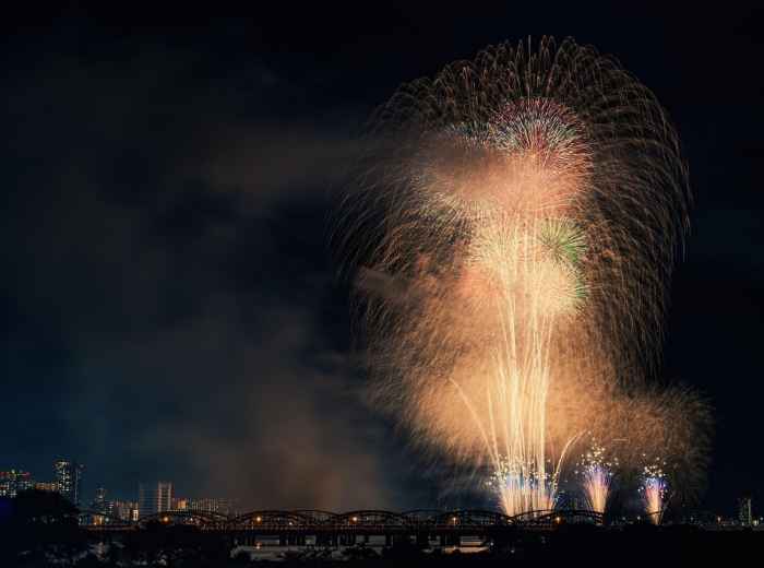 Fireworks over Osaka river during summer festival with boat procession below Image by Kanenori from Pixabay
