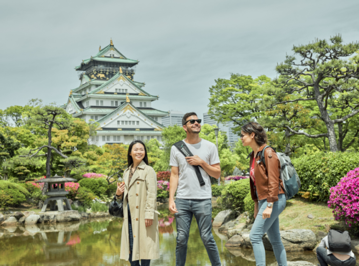 A CU host greeting guests near Osaka Castle