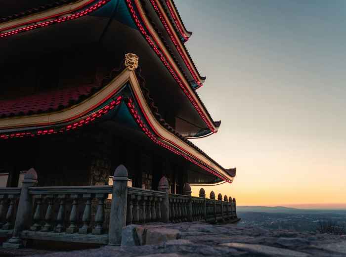 Golden hour light hitting snow-covered temple roofs with dramatic shadows across traditional architecture Photo by Andre Frueh on Unsplash