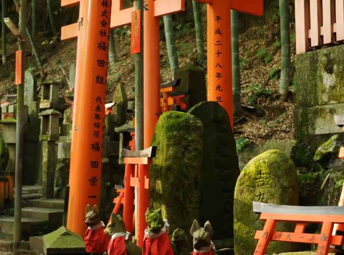 Small fox statues (inari messengers) with offerings of rice and sake at their feet Photo by Nina Perminova on Unsplash