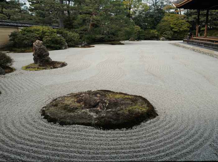 Traditional zen rock garden with carefully raked gravel patterns. Image by fan yang from Unsplash